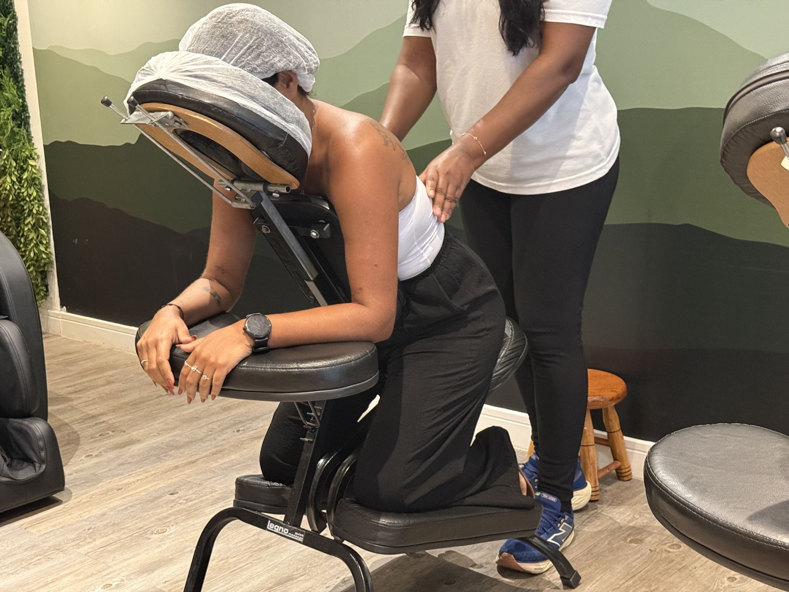 Terapeuta da Sense fazendo quick massage nas costas de cliente sentada na cadeira